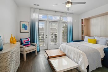 A bedroom with a bed and a sliding glass door